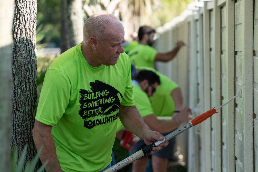 Verdex Volunteer Paints Fence for HomeSafe